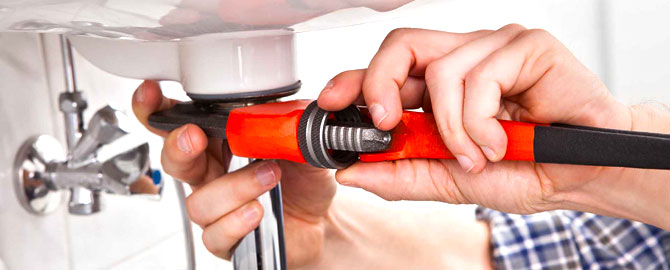 Dealing with a Scarborough Drain Clog - What NOT to Do 7 hands of a scarborough plumbing contractor holding a wrench while working on the drain of a bathroom sink