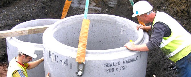 licensed plumbers in toronto overseeing the installation of a manhole